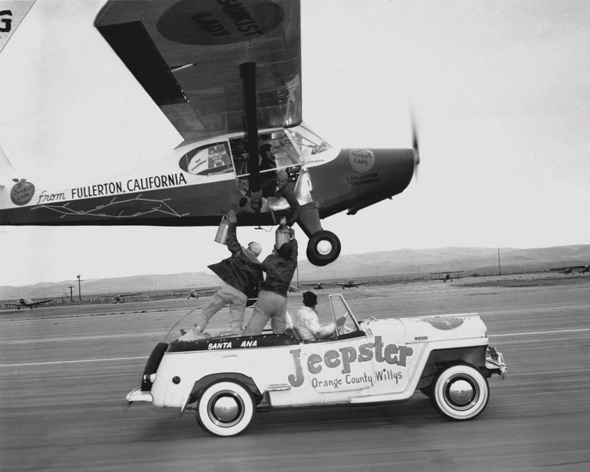 Dick Riedel and Bill Barris form up with a Jeepster to take on supplies during their 1949 record flight. Ground resupply became the norm for endurance record attempts in 1939 and after.