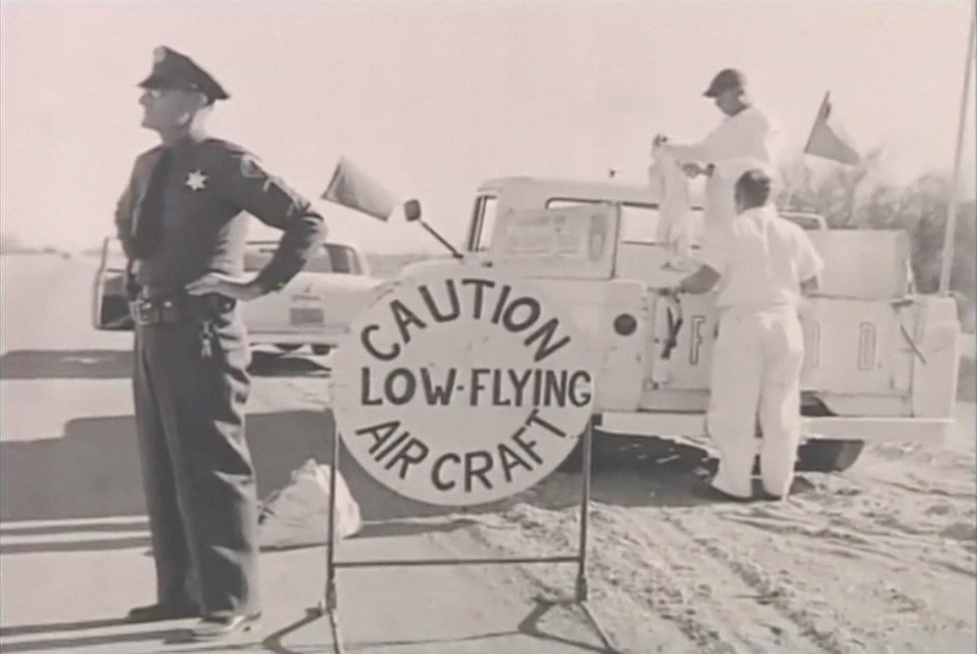 A highway patrol officer blocks the highway while the ground crew for Timm and Cook prepare the resupply truck.